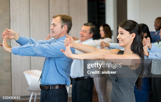 Latin American business group at the office making a work pause and stretching