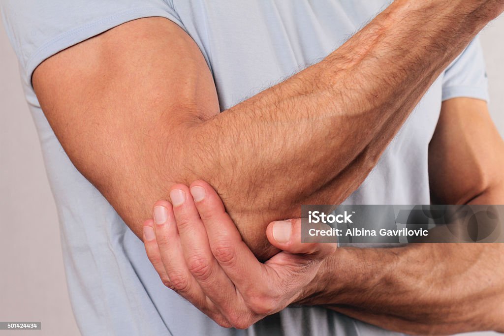 Man With Pain In Elbow. Pain relief concept